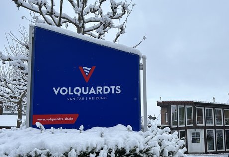 Zu sehen ist das verschneite Firmenschild der Peter Volquardts GmbH am Eingang des Betriebsgeländes.